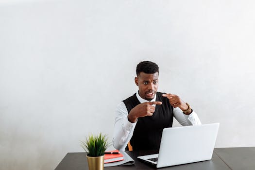 a person working on a laptop, engaging in an online meeting